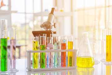 Chemical reagent in scientific experiment flasks of various shapes, sizes and with orange light.