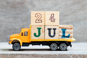 Truck hold letter block in word 24jul on wood background (Concept for date 24 month July)