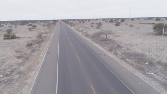Right-traveling aerial drone view move of the Panamerican Roadway on the Sechura Desert between Piura and Lambayeque Regions in Peru