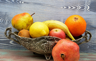 fresh fruits in a basket on wooden background
