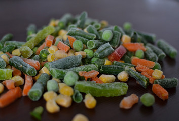 Corn, green beans, green peas, carrots, peppers and onions in hoarfrost.
