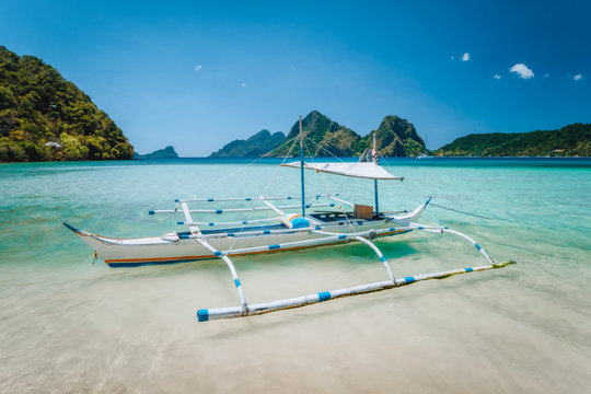 El Nido, Palawan, Philippines. Local tourist banca boat for island hopping trip. Beautiful mountains in background