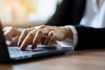 Closeup woman hands typing on laptop computer keyboard