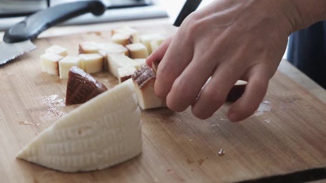 Close up footage at kitchen, woman cutting, preparing Circassian cheese on the cutting board.