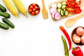 Autumn harvest. Vegetables - potato,cucumber, corn, greenery - frame on white background top-down copy space