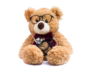 Brown doctor teddy bear with eye glasses and medical stethoscope isolated on white background.