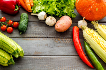 Set of autumn vegetables - potato, cucumber, carrot, greenery - on wooden background copy space