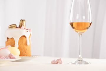 selective focus of Easter cake with eggs near wine glass and meringue