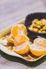 Quartiers de mandarine et bol de grains de maïs