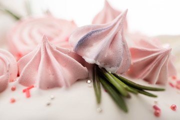 Close up view of delicious easter cake with pink meringue and rosemary