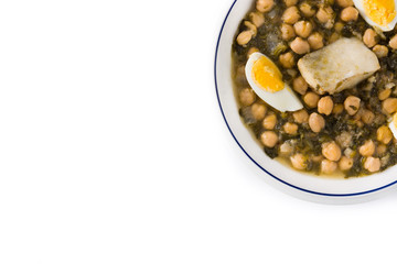 Chickpea stew with spinach and cod or potaje de vigilia isolated on white background. Top view copy space