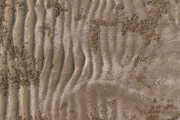 Closeup of sand pattern of a beach in the summer.