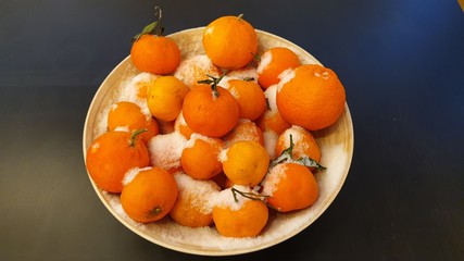 Snowy oranges in a wooden bowl