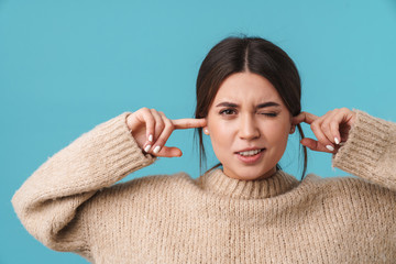 Image of nice young woman winking and plugging her ears