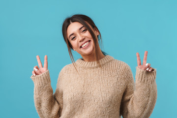 Image of joyful caucasian woman smiling and gesturing peace sign
