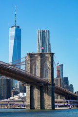 The Brooklyn Bridge with an American Flag over the East River with the Lower Manhattan New York City Skyline