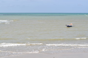 Fishing boat floating in the sea near beach