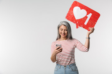 Image of adult woman holding cellphone and heart like symbol on placard