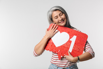 Image of adult mature happy woman holding heart like symbol on placard