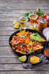 Chips nachos with beef, guacamole, chili, cheese salsa, tequila