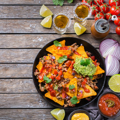 Chips nachos with beef, guacamole, chili, cheese salsa, tequila