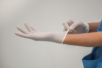 Medical personnel are wearing gloves to prevent infection in the hospital.