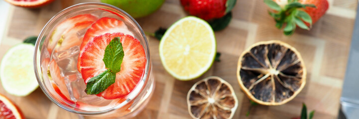 Glass poured cocktail with slices strawberries