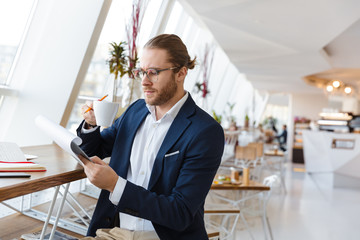 Serious young businessman holding clipboard