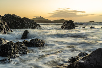 Fototapeta na wymiar Ballycotton Lighthouse at sunrise, beautiful landscape and one of only two black lighthouses in Ireland.