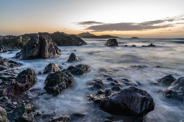 Obraz premium Ballycotton Lighthouse at sunrise, beautiful landscape and one of only two black lighthouses in Ireland.