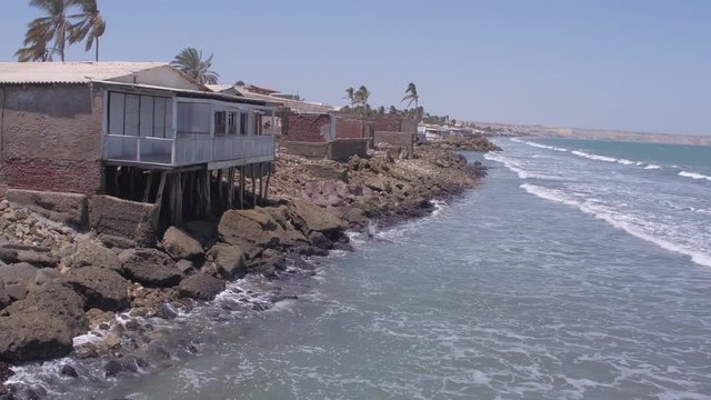 Static and pullback aerial drone view of houses on Colan Beach at a sunny day in Piura Region, Peru