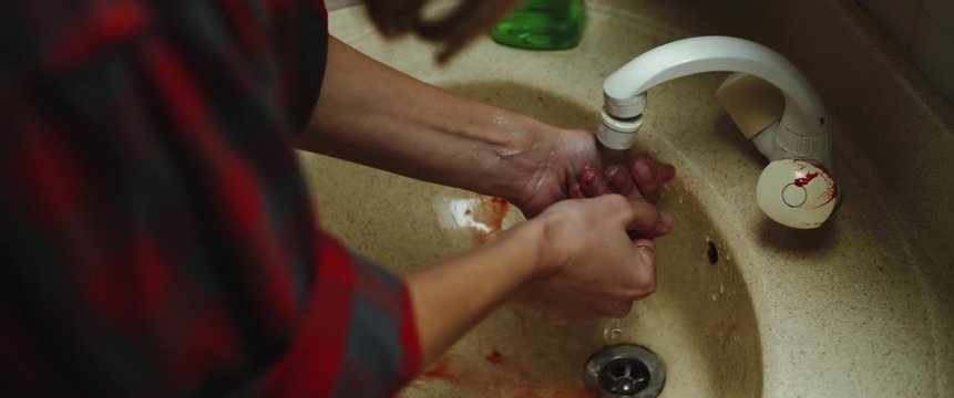 Woman washing bloody hands in the sink, close up. Horror murder  concept. BMPCC 4K