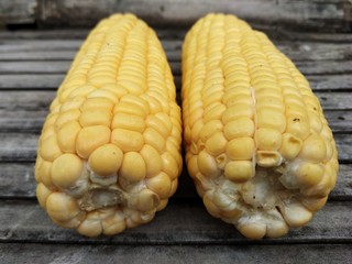 two jumbo-sized corn on a bamboo board