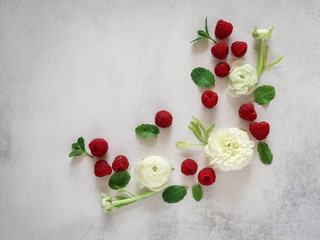 Creative arrangement white blooms and raspberries on a grey background with a copy space