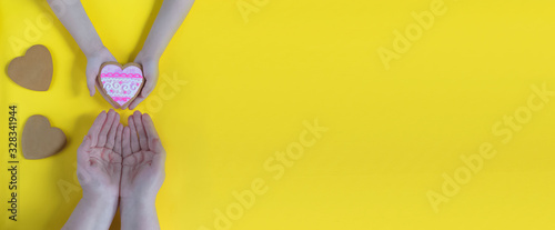 Happy mother's day.Women's day.I love you.Heart in the hands of daughter and mother on a yellow background.Love and health in the family.Banner for the store.Greeting card.copyspace