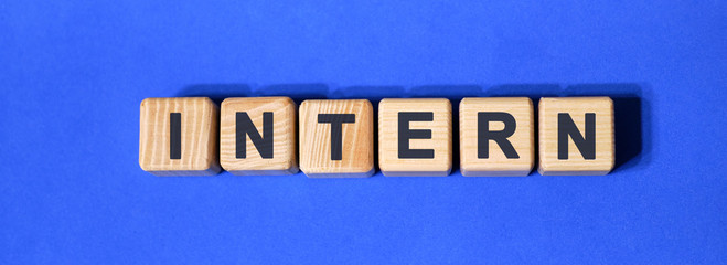 INTERN on wooden cubes on a blue background
