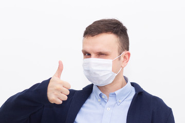 Portrait of a man on a white isolated background, face covered with a medical mask, banner for text. Health, awareness, and timeliness. Healthy lifestyle. No viruses.