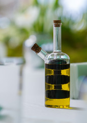 glass jar with oil in a vintage bottle stands on a served table