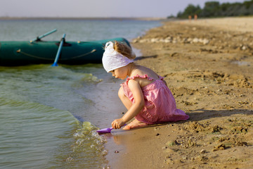  Little girl with a boat on the lake, summer, vacation, travel.