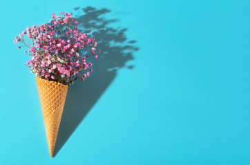 Small bouquet on a blue background. Pink flowers. Waffle