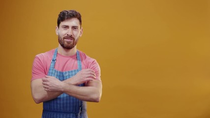 Young chef sexy baker in blue apron shaking off powder flour posing confident face expression crossing arms posing on background copy space. Confectionery concept.