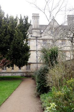 Gardens of Oxford University. Beautiful historical building with green lawn and trees in garden. Oxford campus.