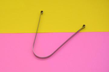 metal tongue scraper on a colored background