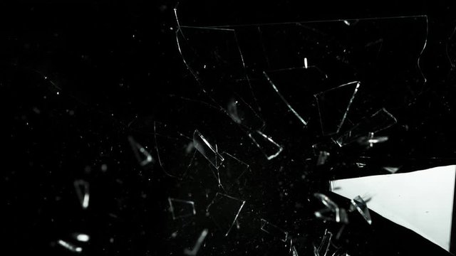 Super slow motion of shattered glass on black background. Filmed on high speed cinema camera, 1000 fps.