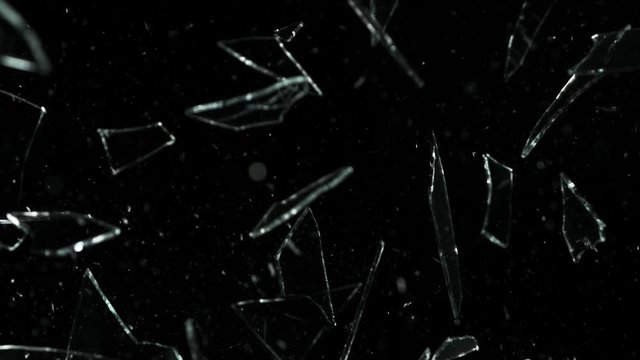 Super slow motion of shattered glass on black background. Filmed on high speed cinema camera, 1000 fps.