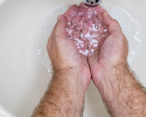 Fototapeta premium Man washing hands close-up from above