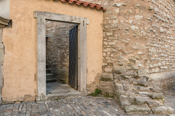 Fototapeta na wymiar Deteriorated house facade. Rustic doorway in a Spanish town