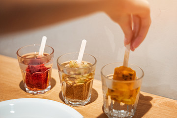 The girl makes fruit tea from frozen billets.