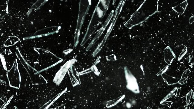 Super slow motion of shattered glass on black background. Filmed on high speed cinema camera, 1000 fps.