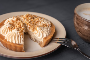 Dessert basket with salted caramel cut and lies on a plate next to a fork for dessert and cappuccino.